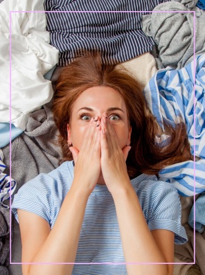 Woman surrounded by a pile of clothes
