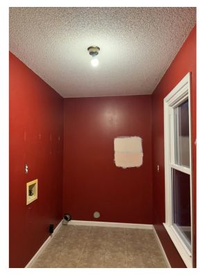 Before photo of red laundry room with popcorn ceilings
